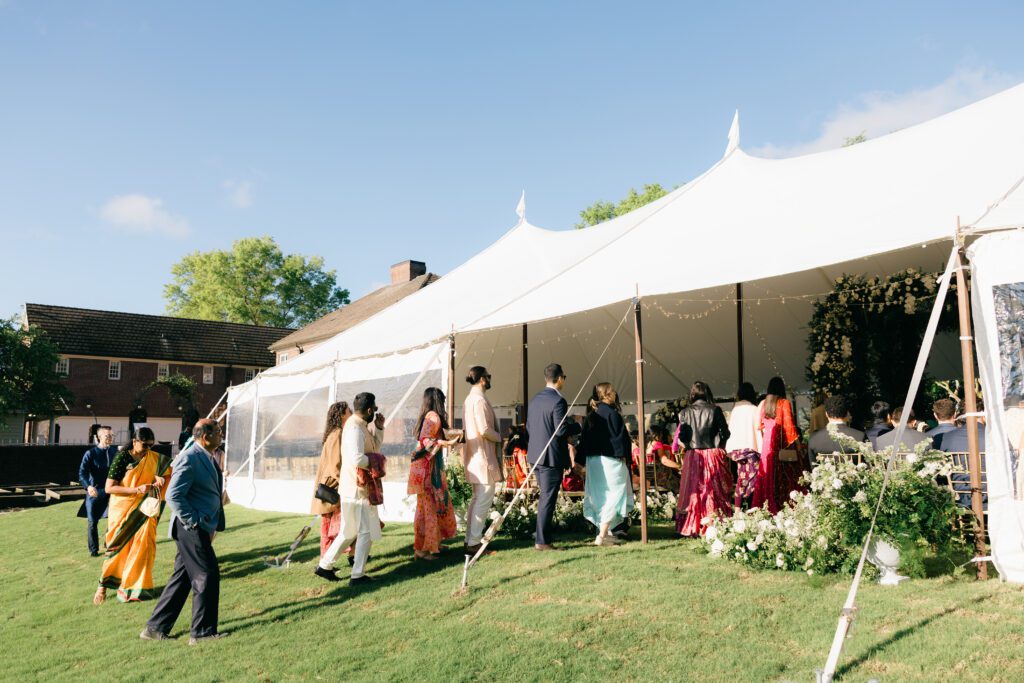 Guests entering sailcloth tent for a wedding ceremony