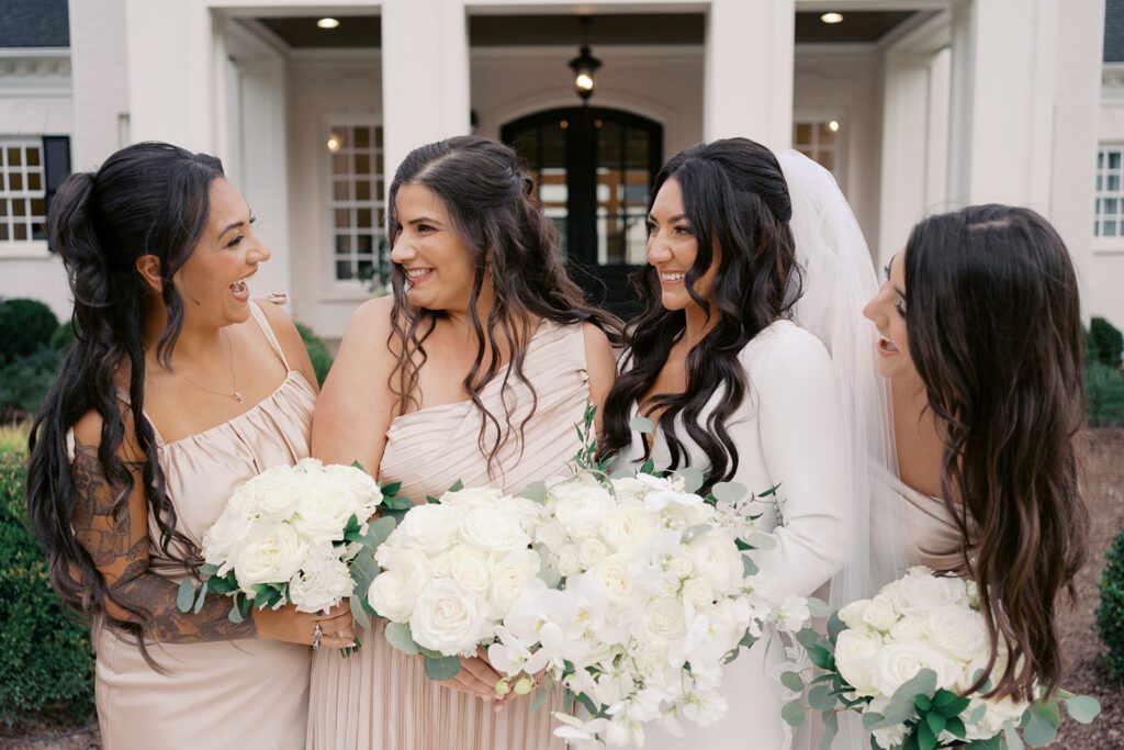 Bride and bridesmaids posing in front of historic mansion
