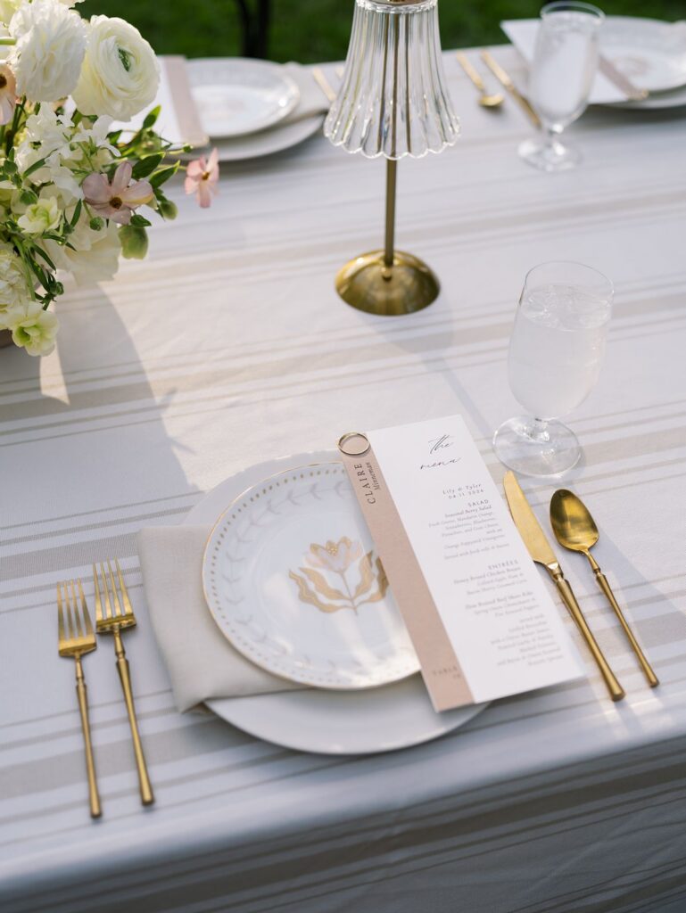 Neutral place setting with taupe wedding menu and gold flatware