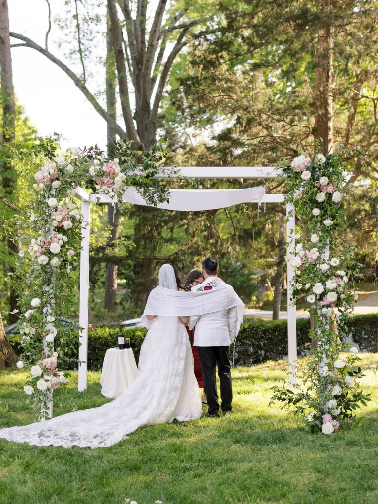 White chuppah with green, pink, and white