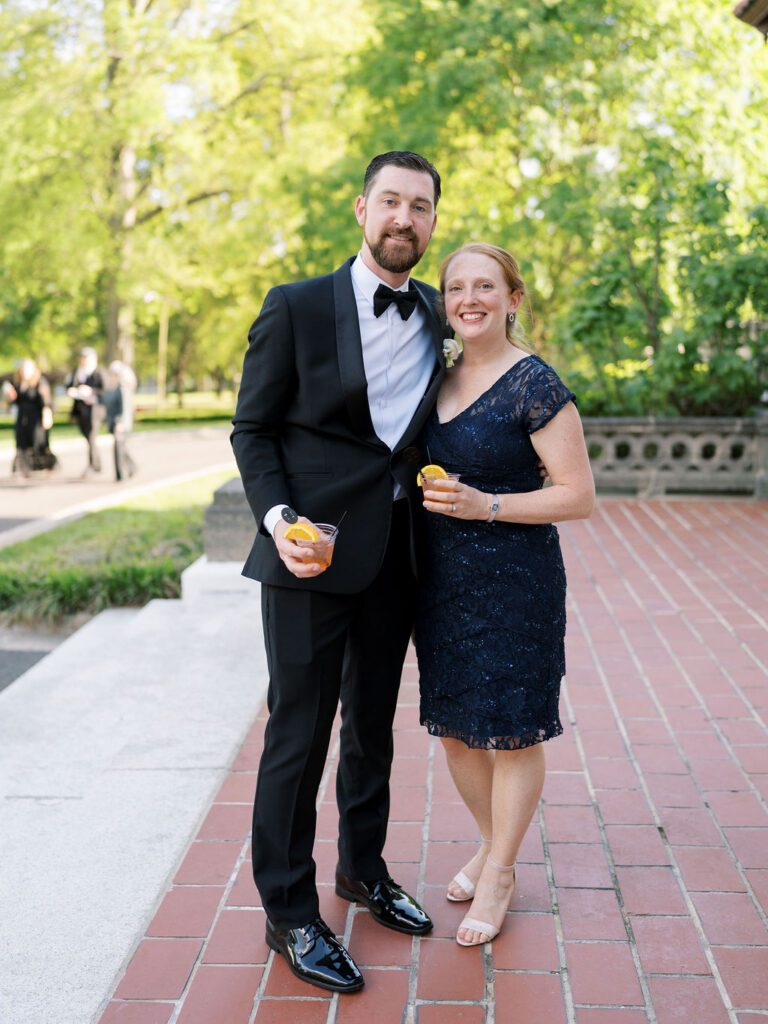 Couple poses with drinks on the patio at hill house