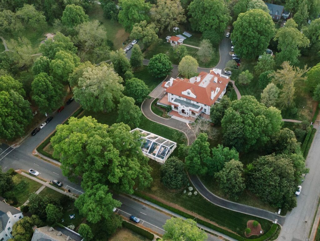 Drone photo of a wedding with clear top tent at Hill House in downtown Durham.