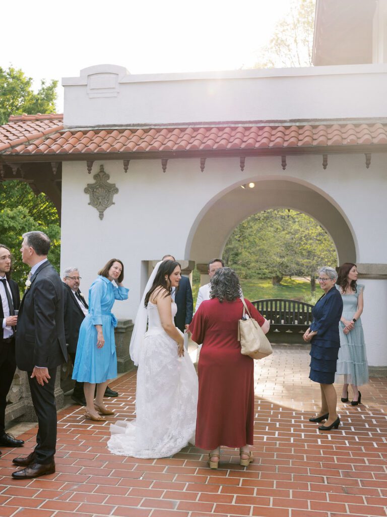 Bride talking to guests during cocktail hour